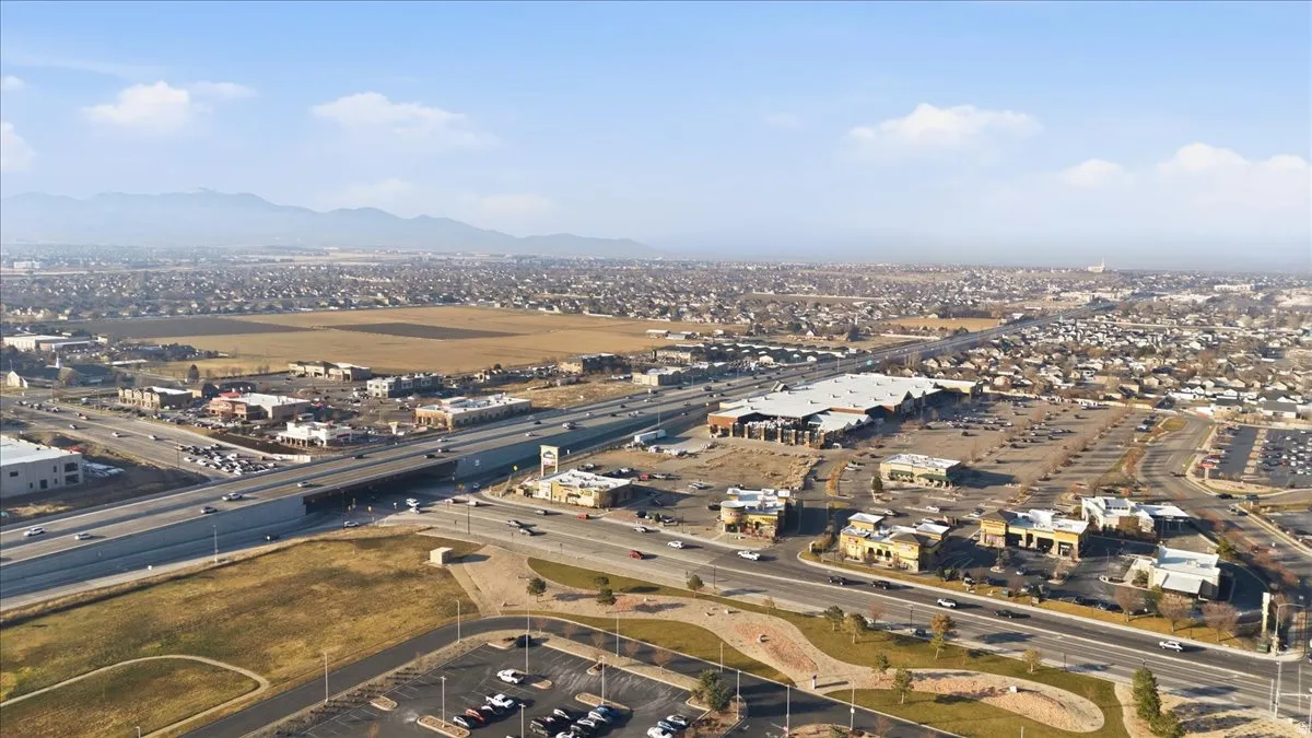 Aerial view of property's location featuring a mountain backdrop and a highway