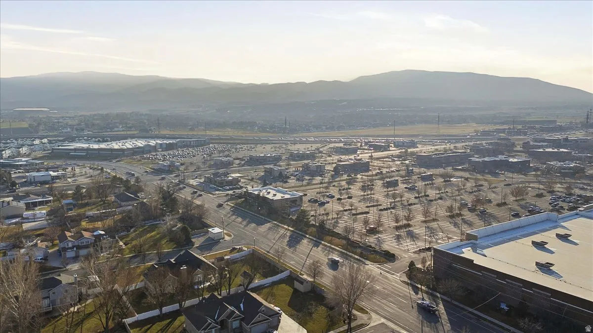 Aerial view of property and surrounding area featuring a mountain backdrop