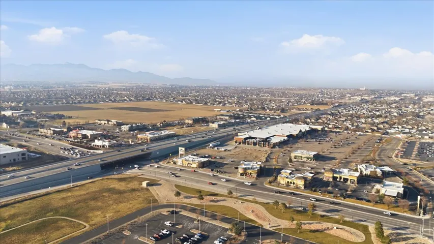 Aerial view of property's location featuring a mountain backdrop and a highway