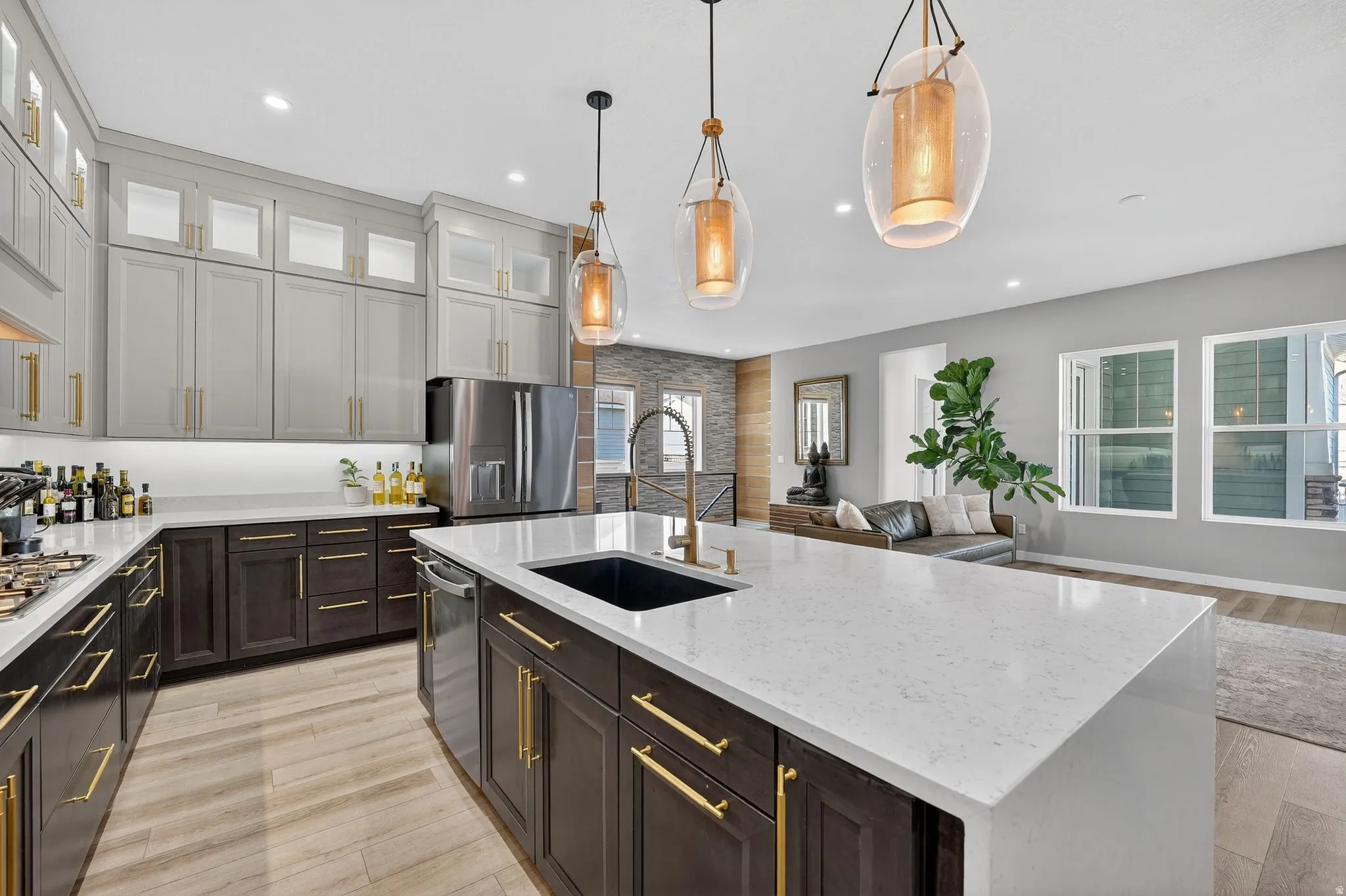 Kitchen featuring light granite countertops, decorative light fixtures, appliances with stainless steel finishes, recessed lighting, and custom range hood and water fall extended island