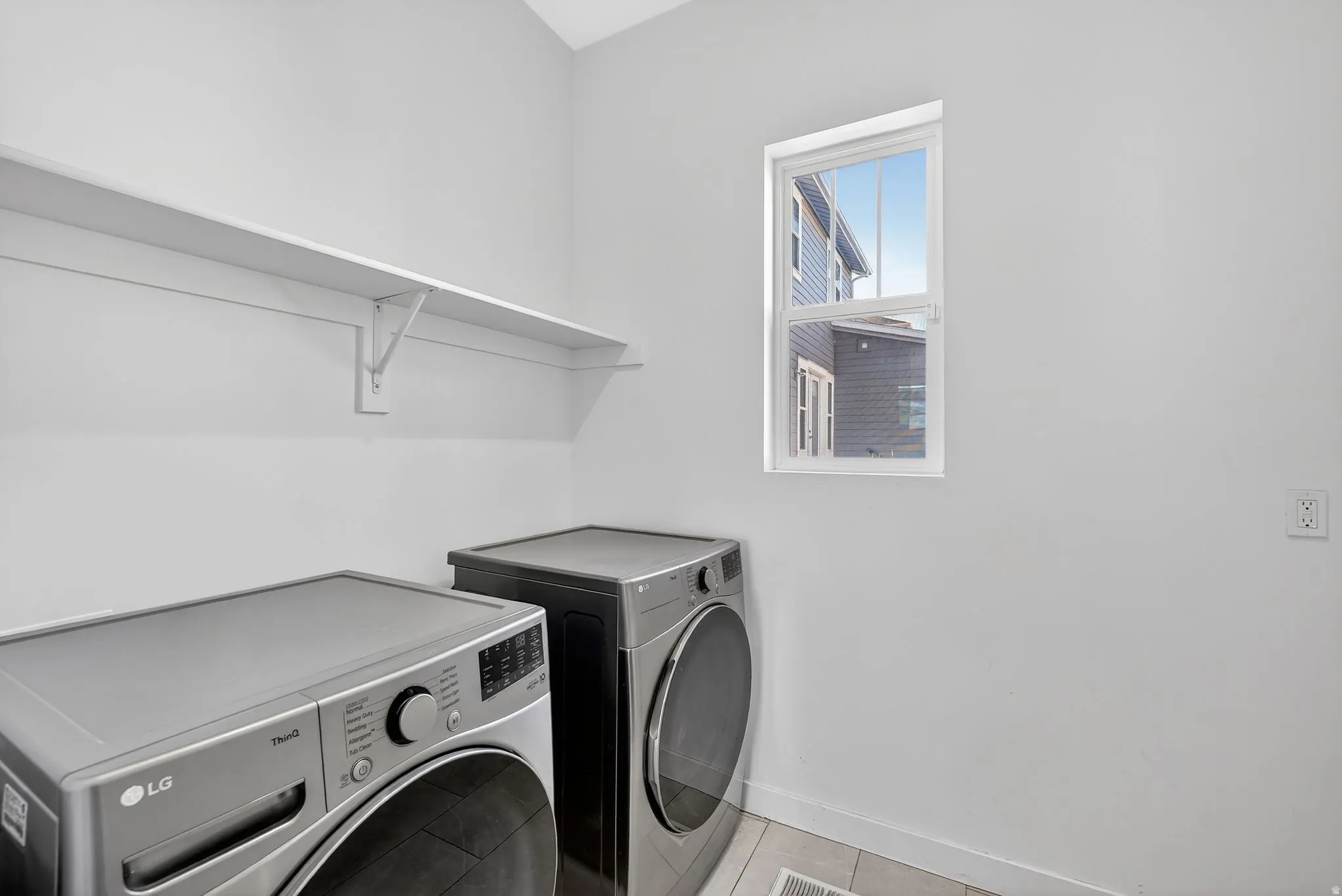Washroom with separate washer and dryer and tile patterned flooring