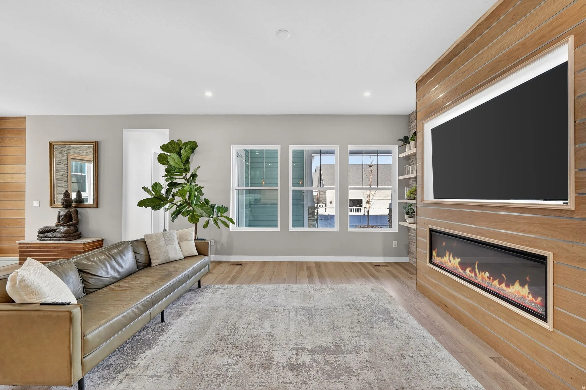 Living room with wood accent wall upgrades, floating shelves, fireplace and included TV