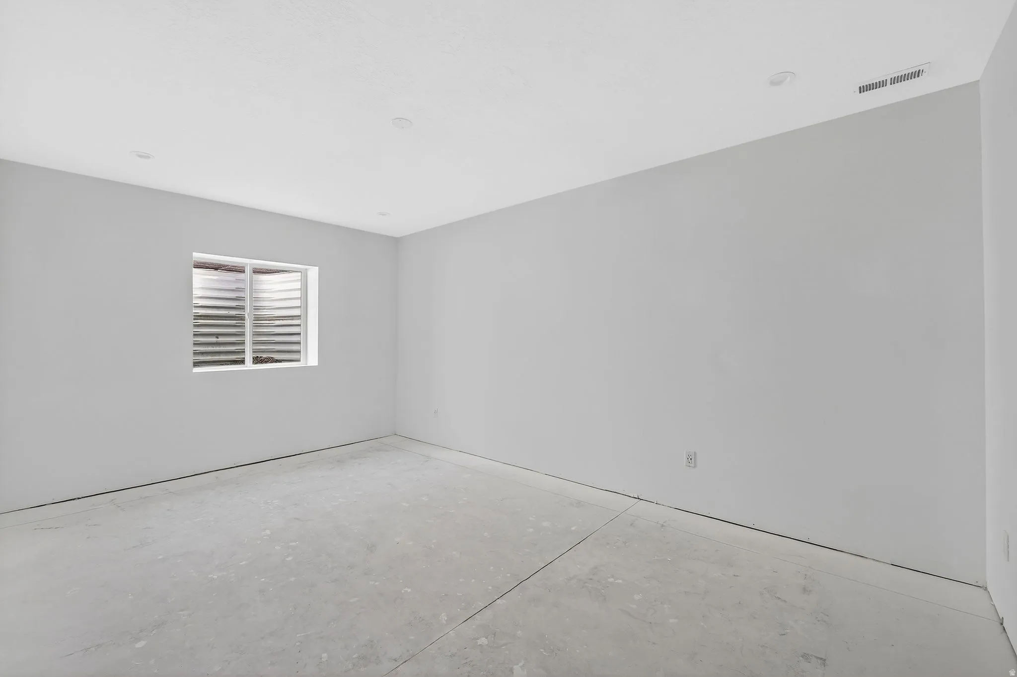 Spare room with unfinished concrete flooring