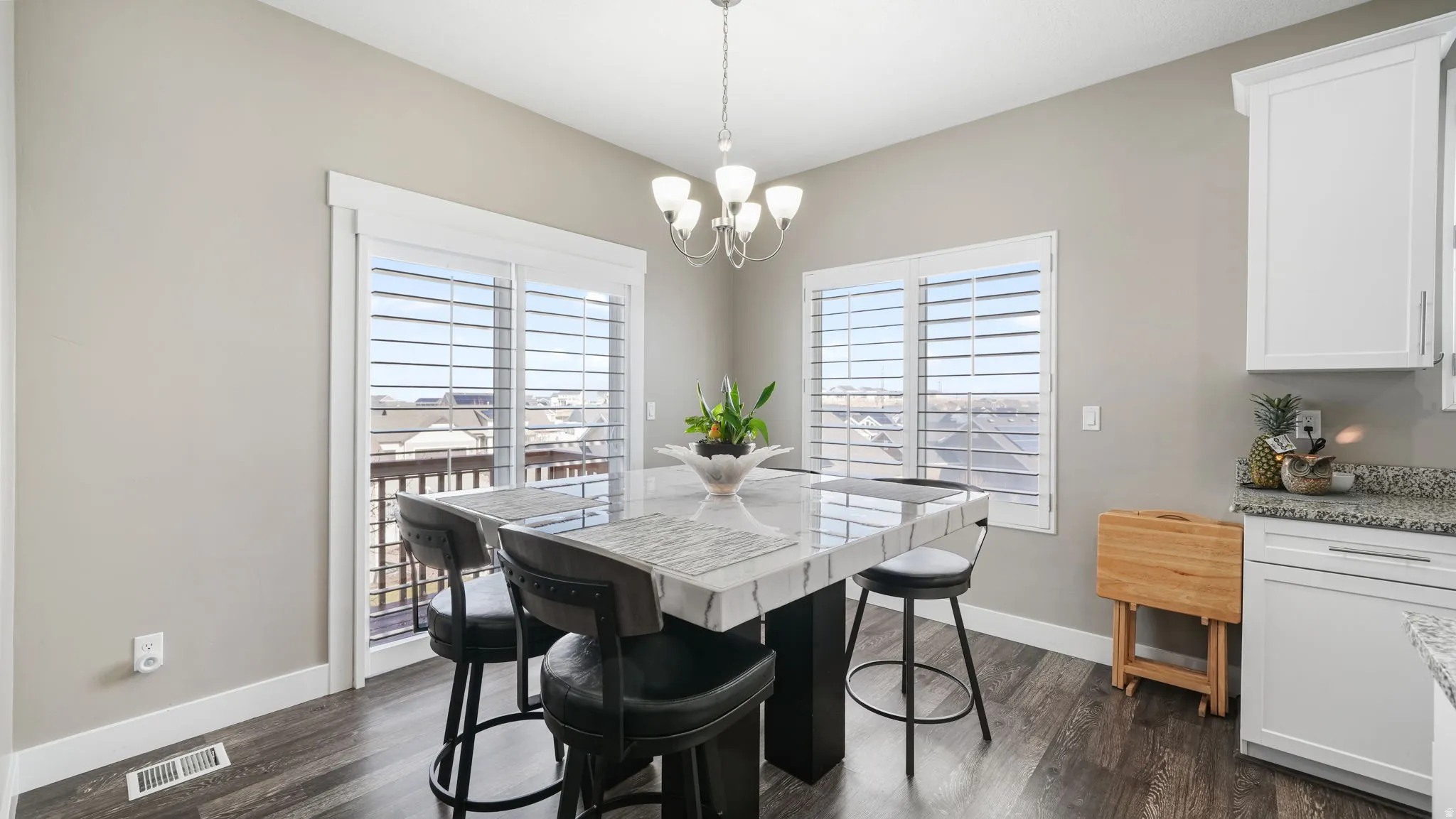 Dining area with dark wood-style flooring and a chandelier