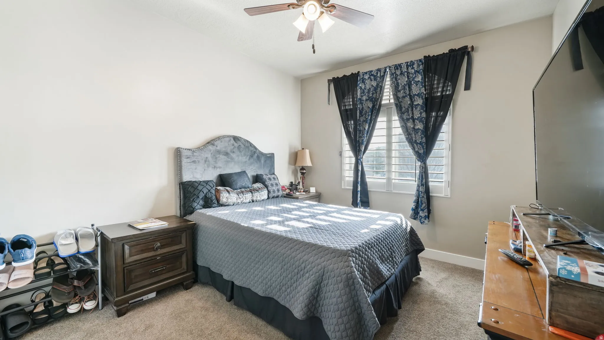 Bedroom with light colored carpet and ceiling fan