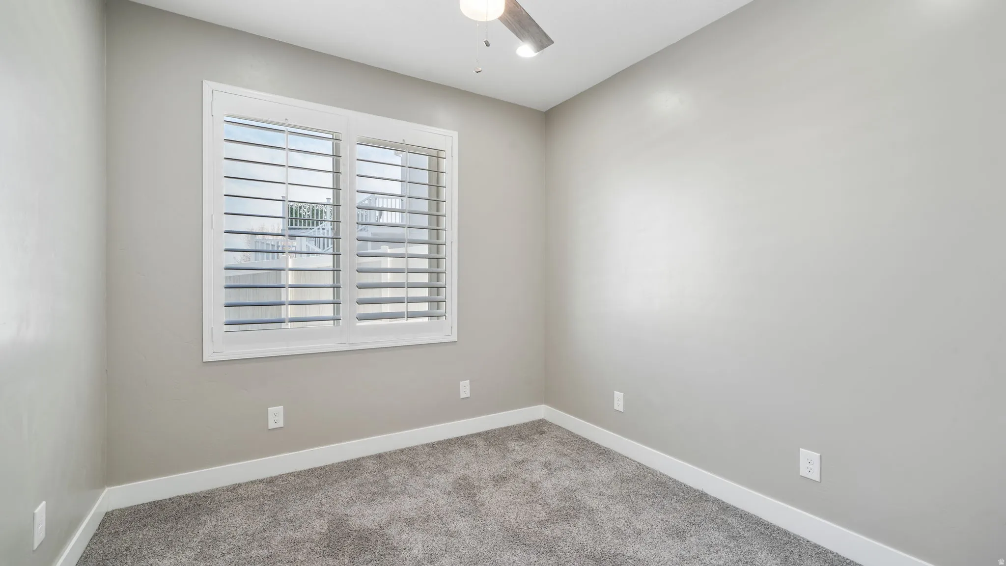 Spare room with carpet and a ceiling fan
