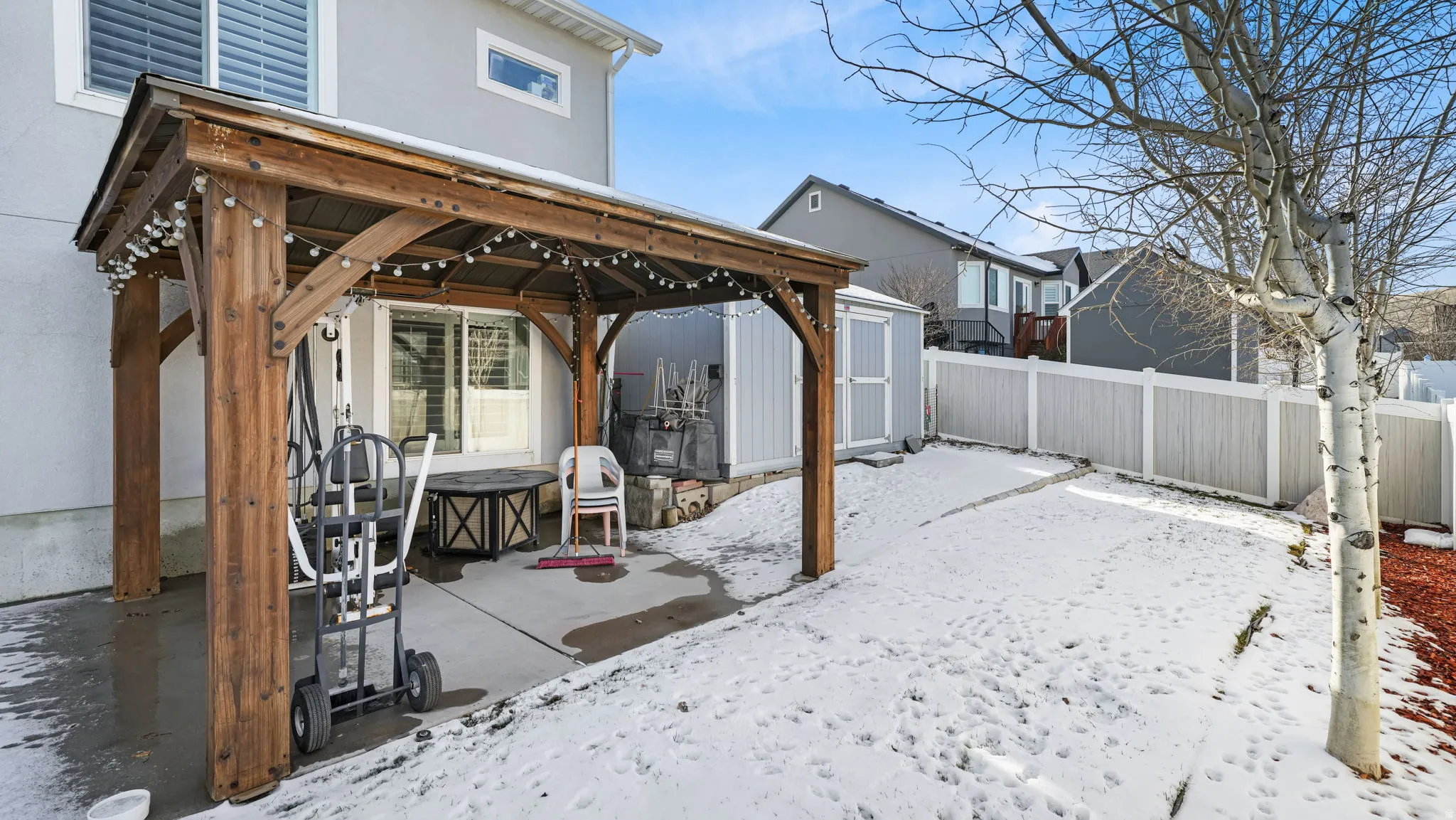 Snow covered patio featuring a gazebo, a patio, and a fenced backyard