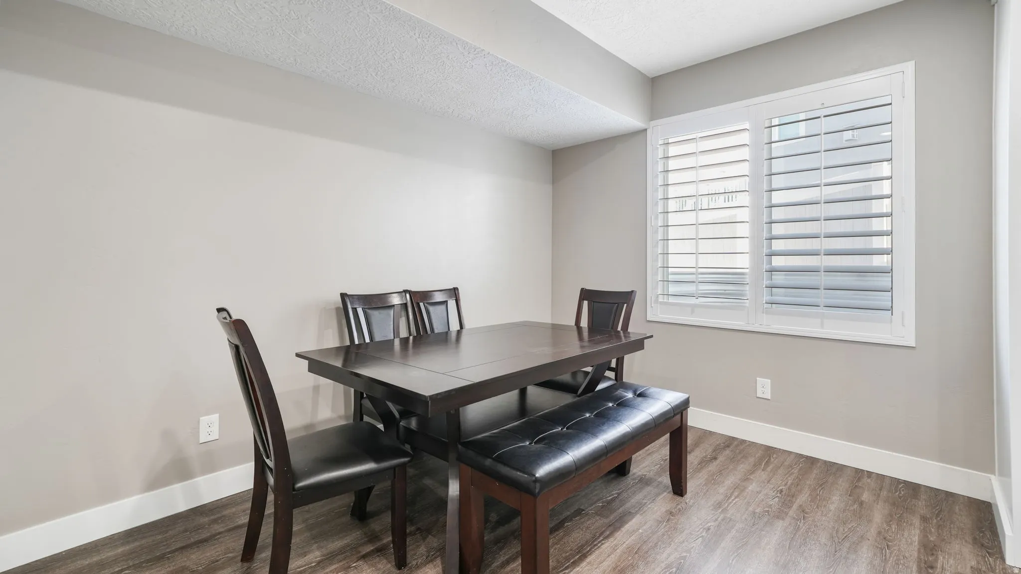 Dining area featuring wood finished floors and a textured ceiling