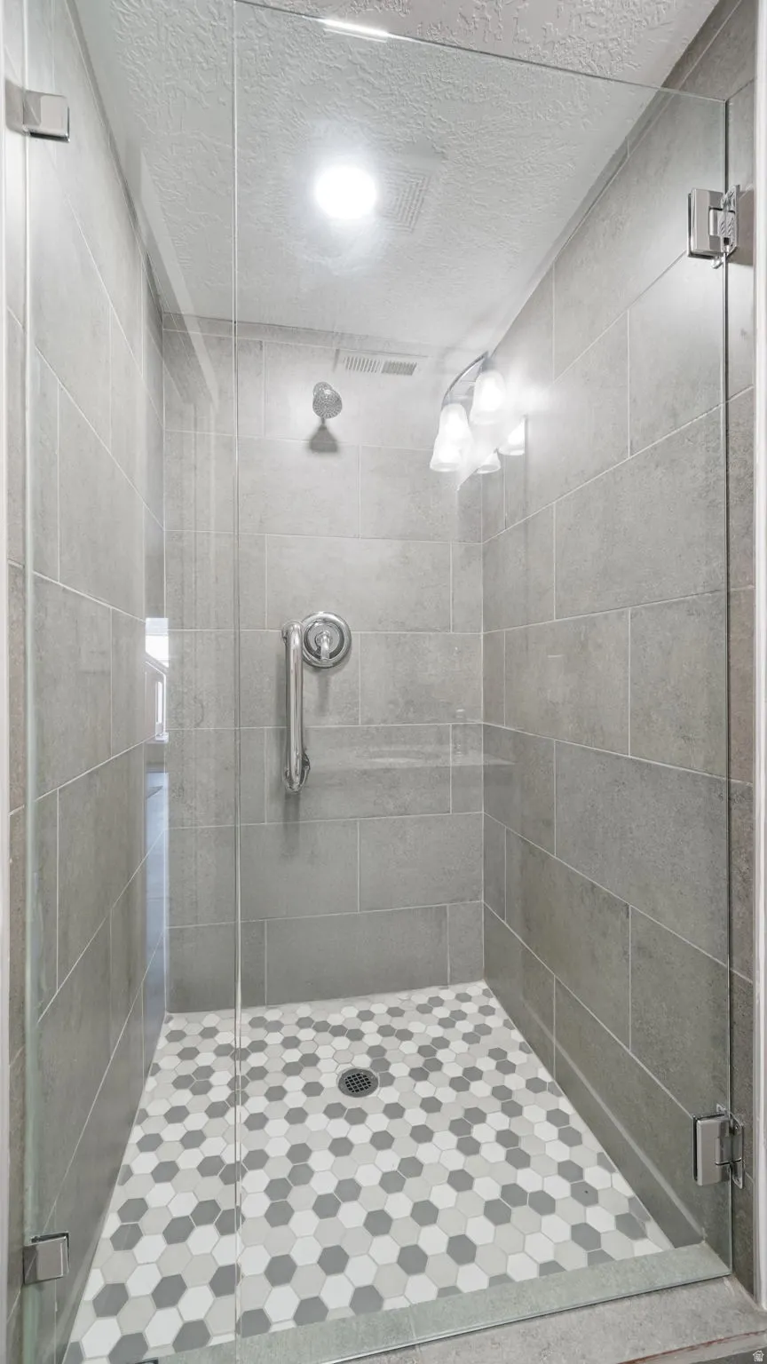 Bathroom with a stall shower and a textured ceiling