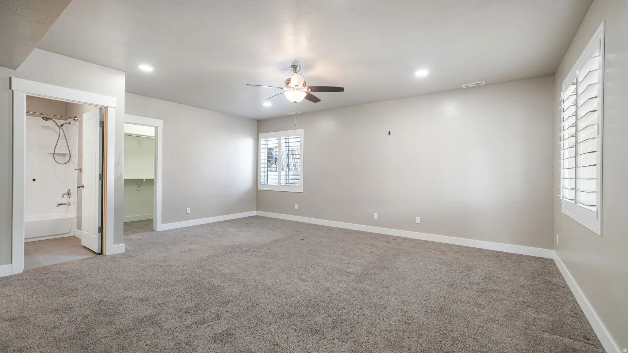 Unfurnished bedroom with recessed lighting, a walk in closet, light carpet, and a ceiling fan