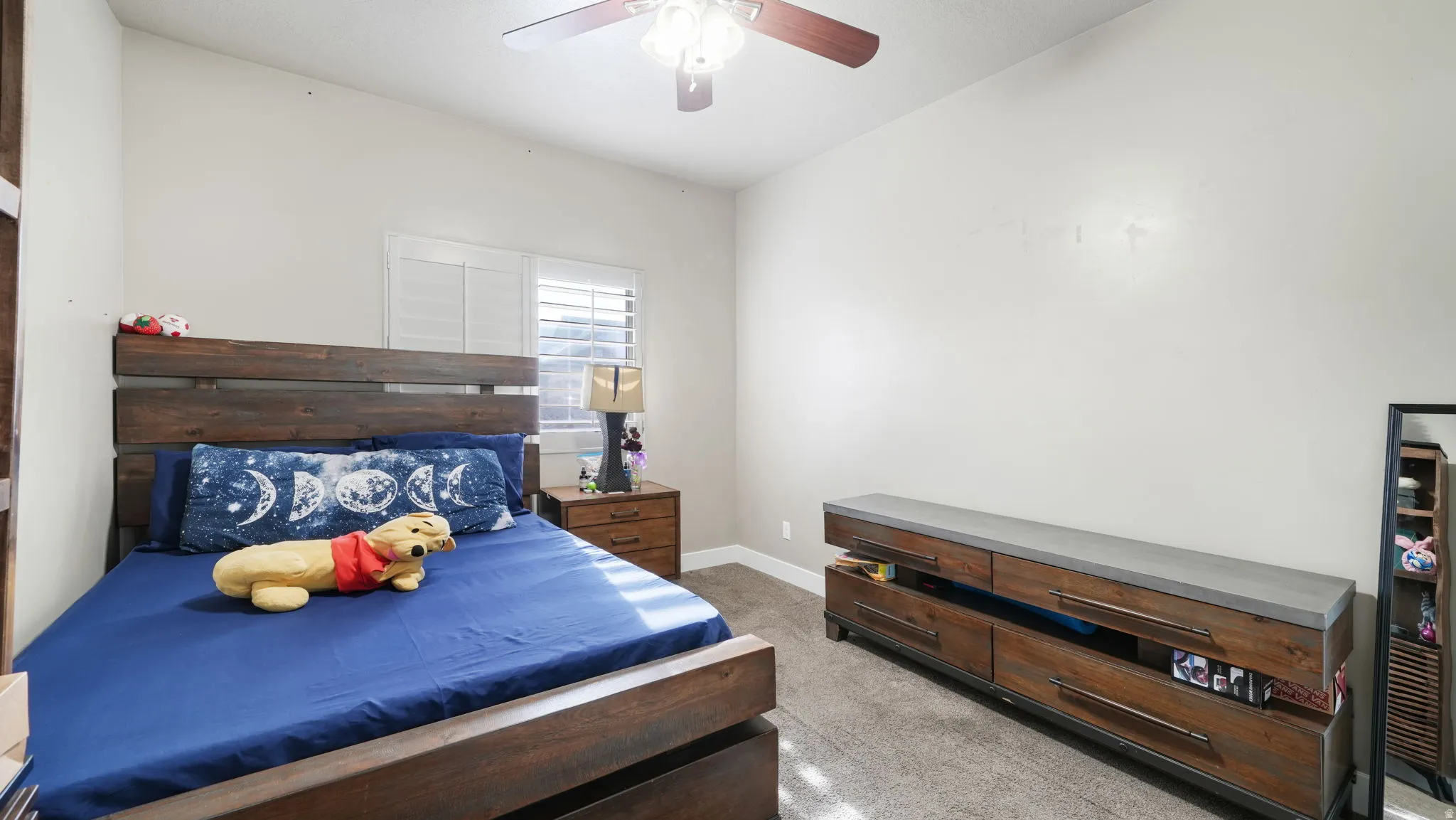 Bedroom with a ceiling fan and light colored carpet
