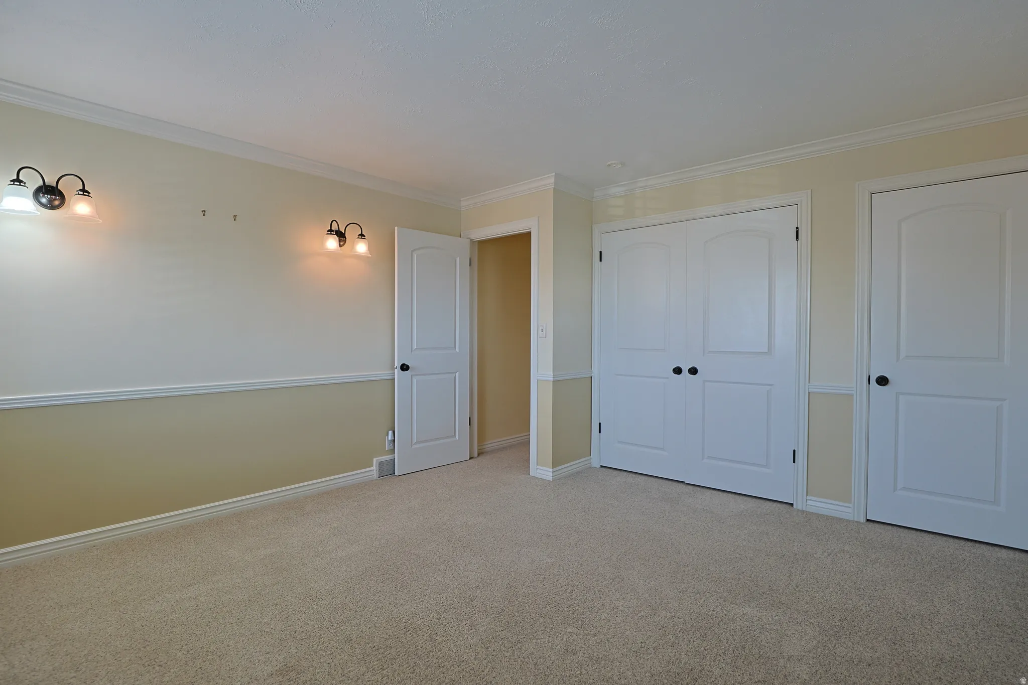 Unfurnished bedroom featuring carpet flooring, crown molding, and a closet