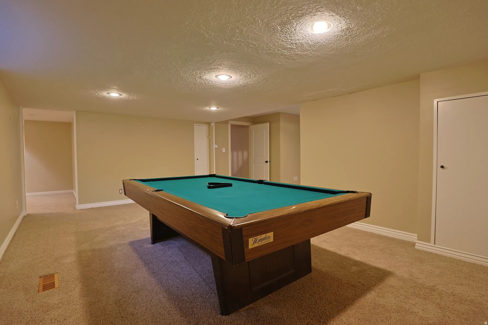 Recreation room with billiards table, a textured ceiling, light colored carpet, and recessed lighting