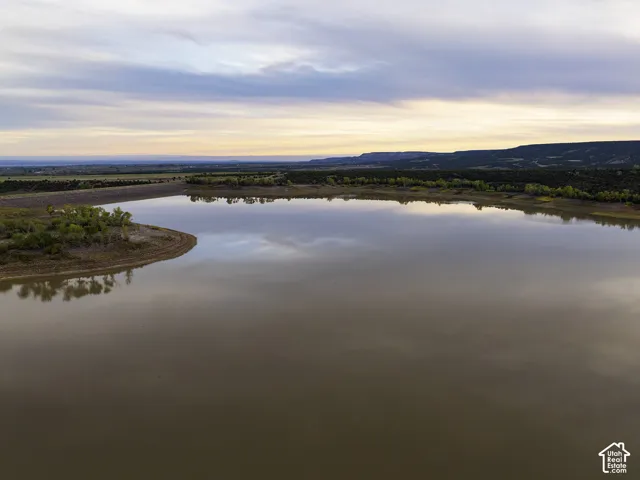 Expansive body of water with a natural shoreline and distant natural landforms