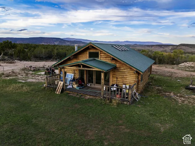 Log cabin exterior with a green metal roof and solar panels
