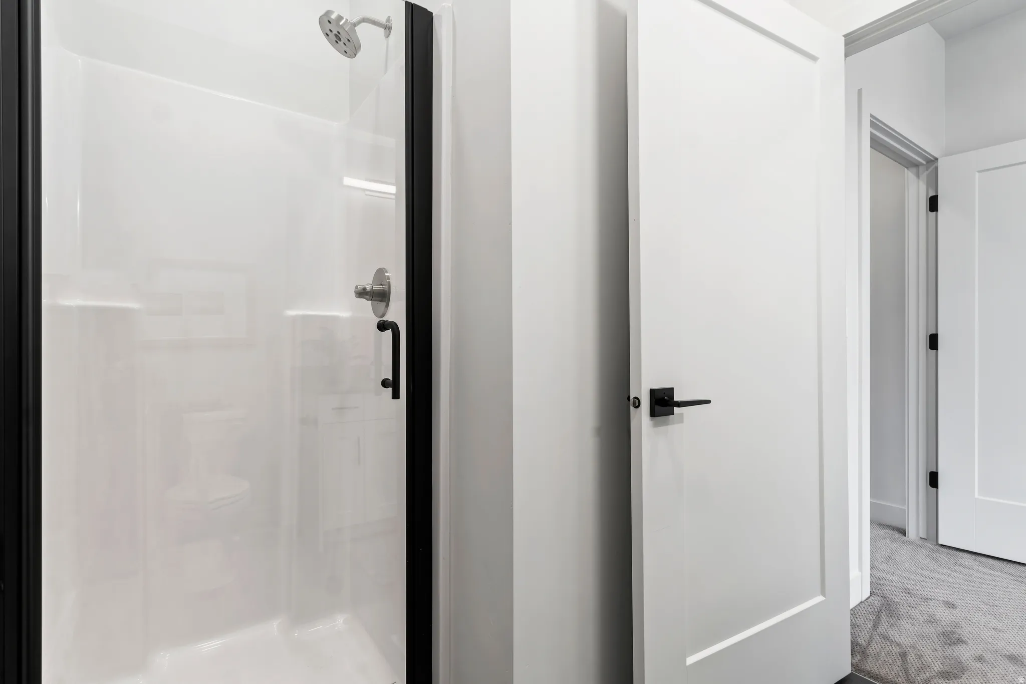 Bathroom with a stall shower and carpet