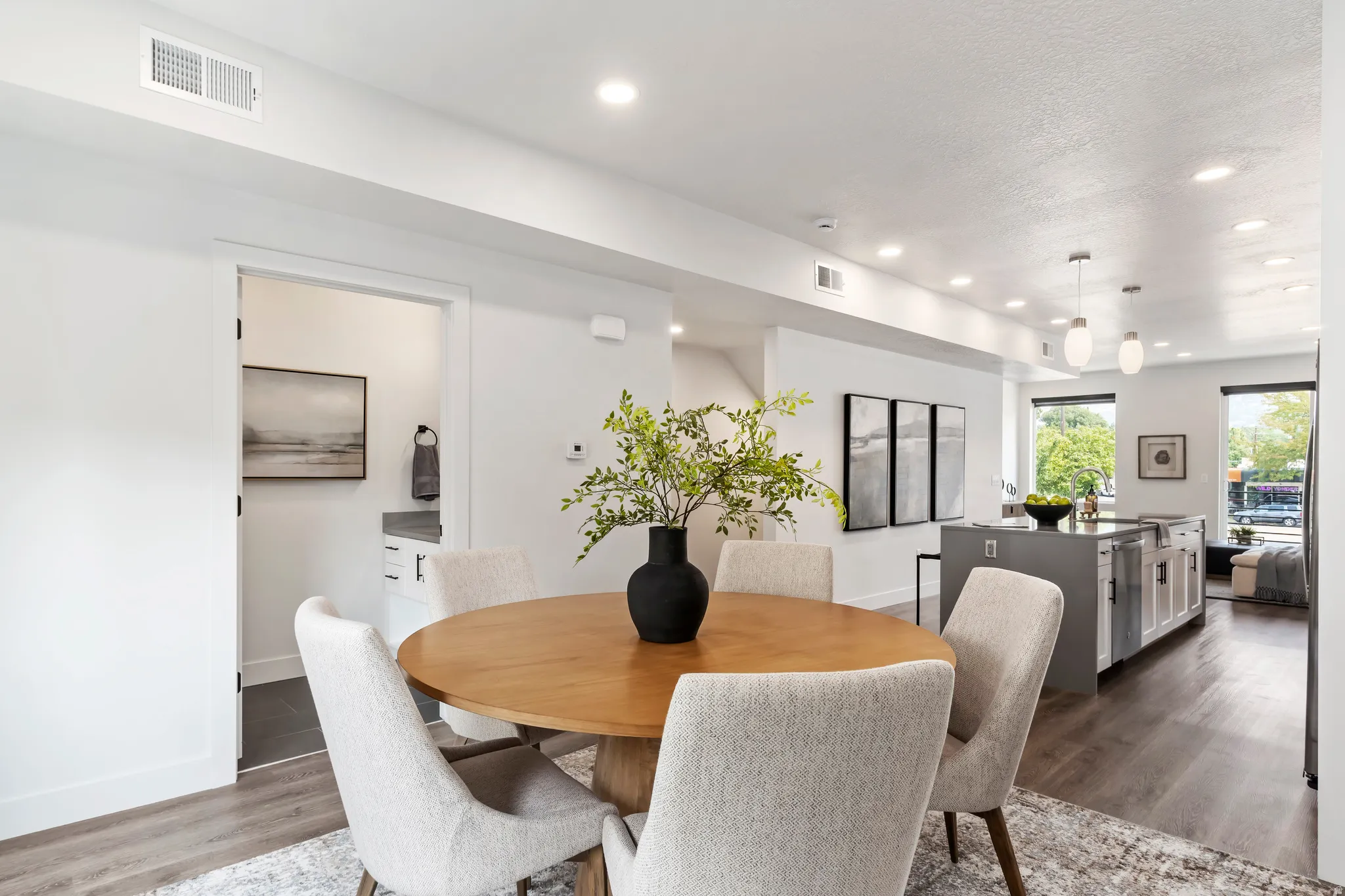 Dining area with wood finished floors, recessed lighting, and a textured ceiling. Model Home