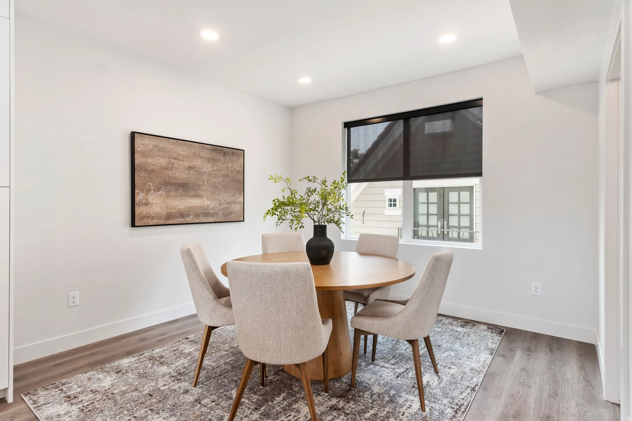 Dining space with light wood finished floors and recessed lighting. Model Home
