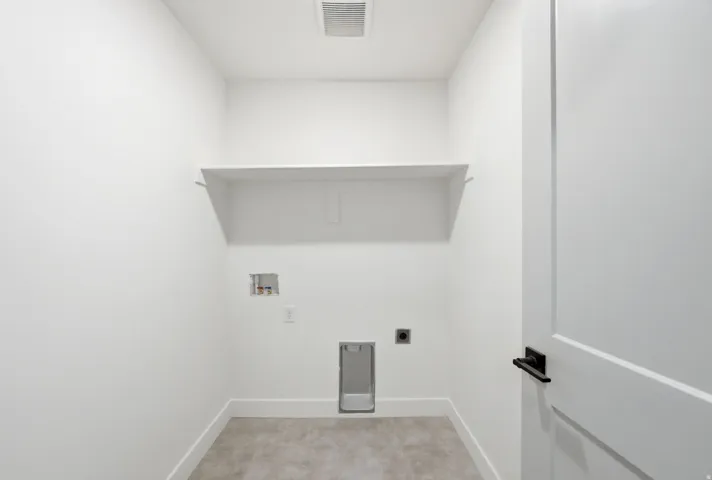 Utility space featuring a built-in shelf, appliance hookups, and a panel door with matte black hardware