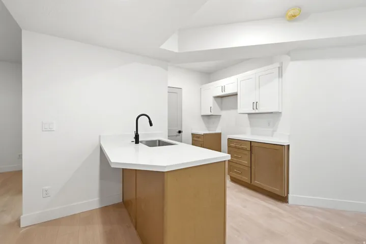 Kitchen island with a stainless steel sink and matte black faucet