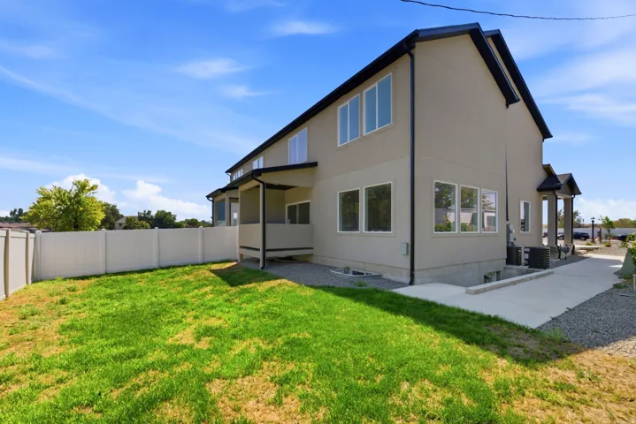Expansive grassy area with a white privacy fence