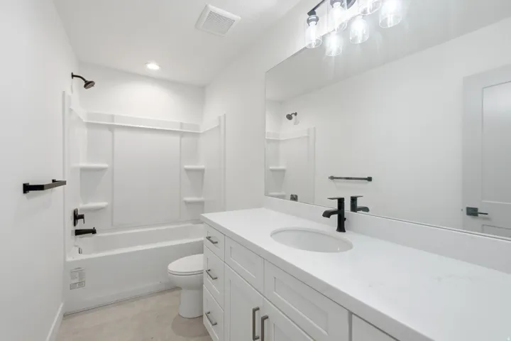 White vanity with a solid surface countertop and undermount sink