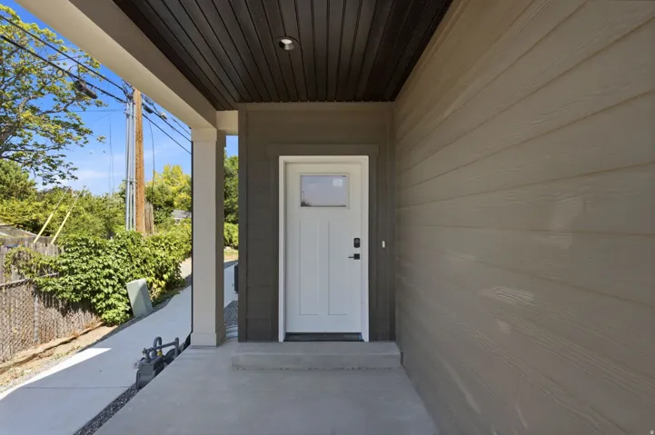 Covered entry with recessed lighting, fiber cement siding, concrete porch, and a white entry door with smart lock