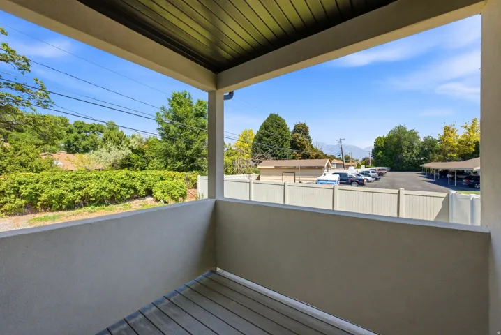 Covered patio with a wood-finish floor and stucco walls