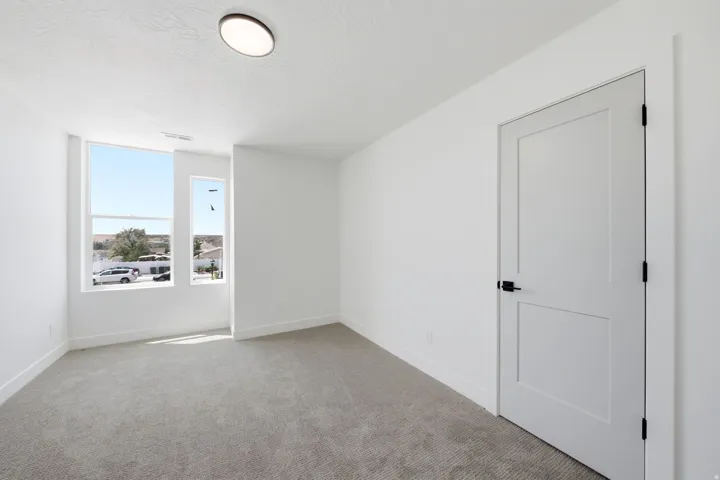 Large windows provide ample natural light, complemented by a flush-mount ceiling light