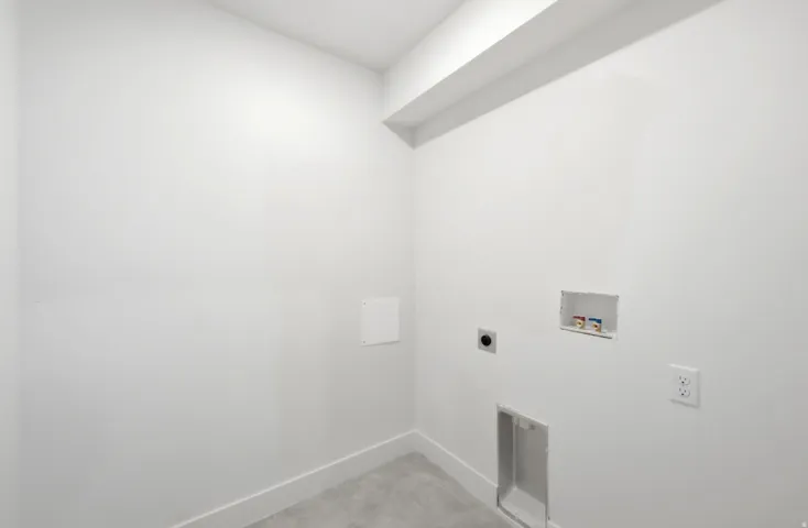 Laundry area featuring a concrete floor, white walls, and dedicated hookups for a washer and dryer