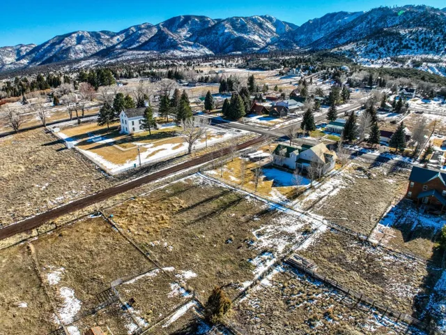 Snowy aerial view featuring a mountain view and a residential view