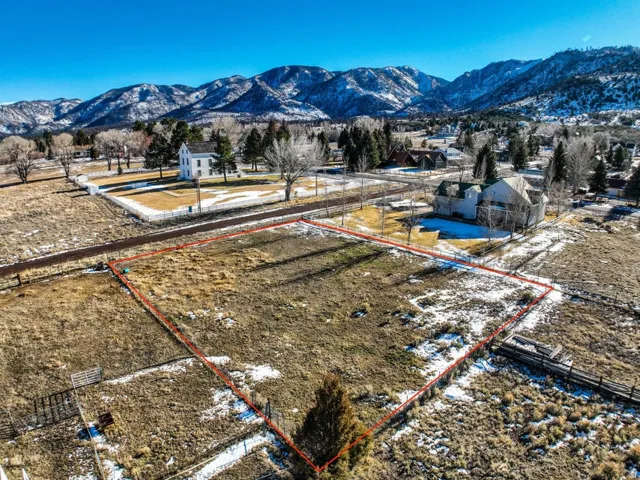 Aerial view of property's location with property parcel outlined and a mountainous background