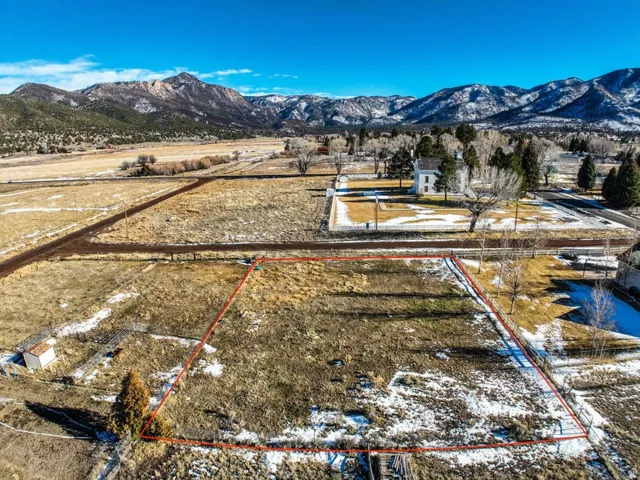 Aerial overview of property's location with a mountainous background and property boundaries highlighted