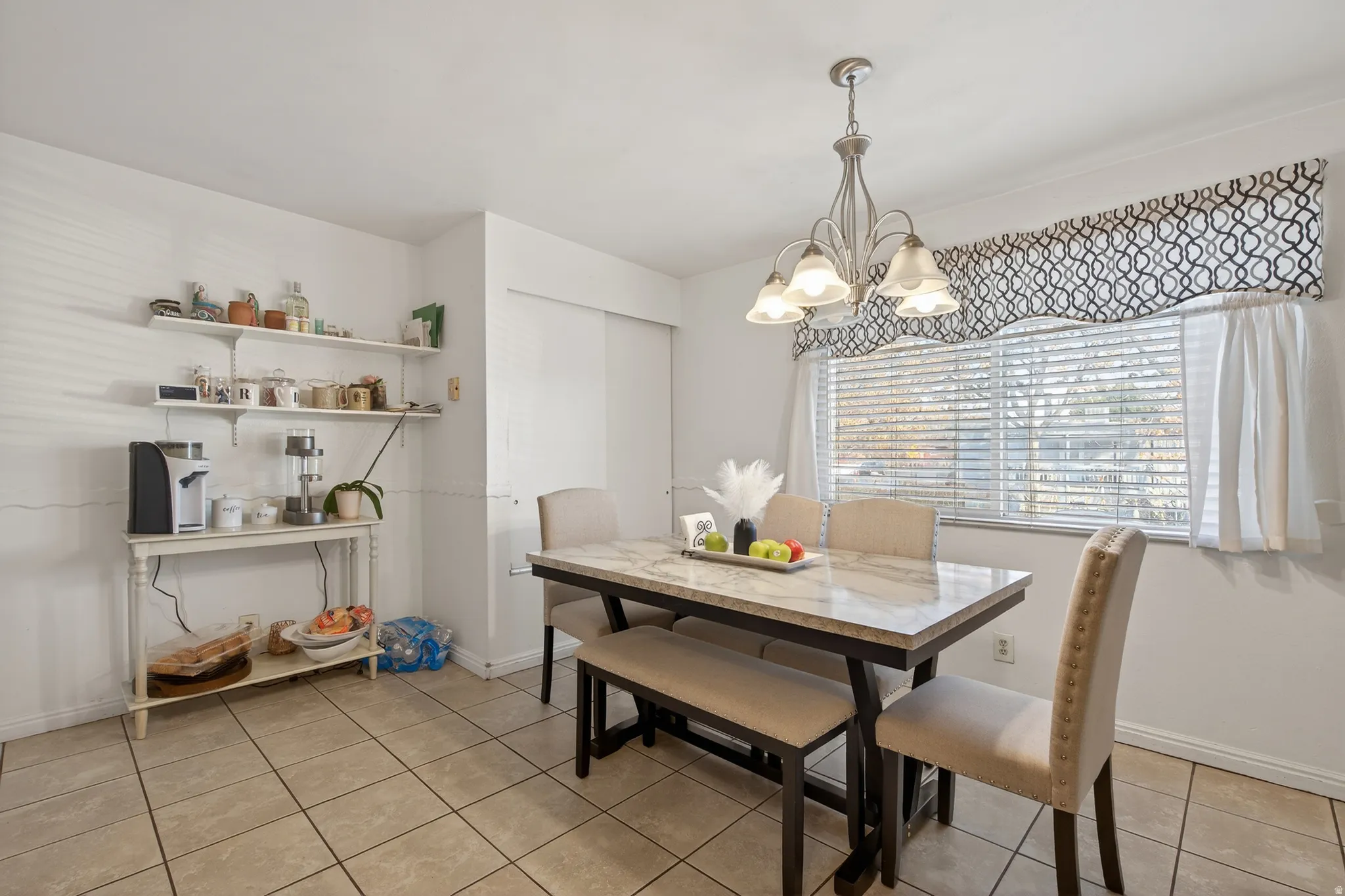 Dining area featuring light tile patterned floors and a chandelier
