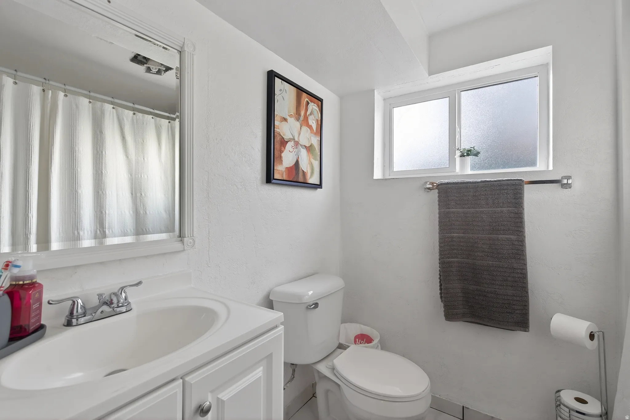 Downstairs bathroom with vanity, curtained shower, and a textured wall