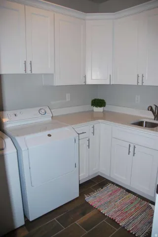 Laundry area featuring cabinet space, wood finish floors, and washing machine and dryer