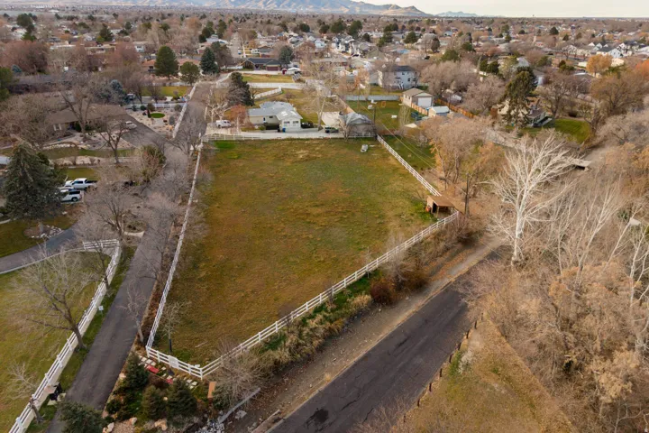 Aerial view of property and surrounding area featuring nearby suburban area and mountains