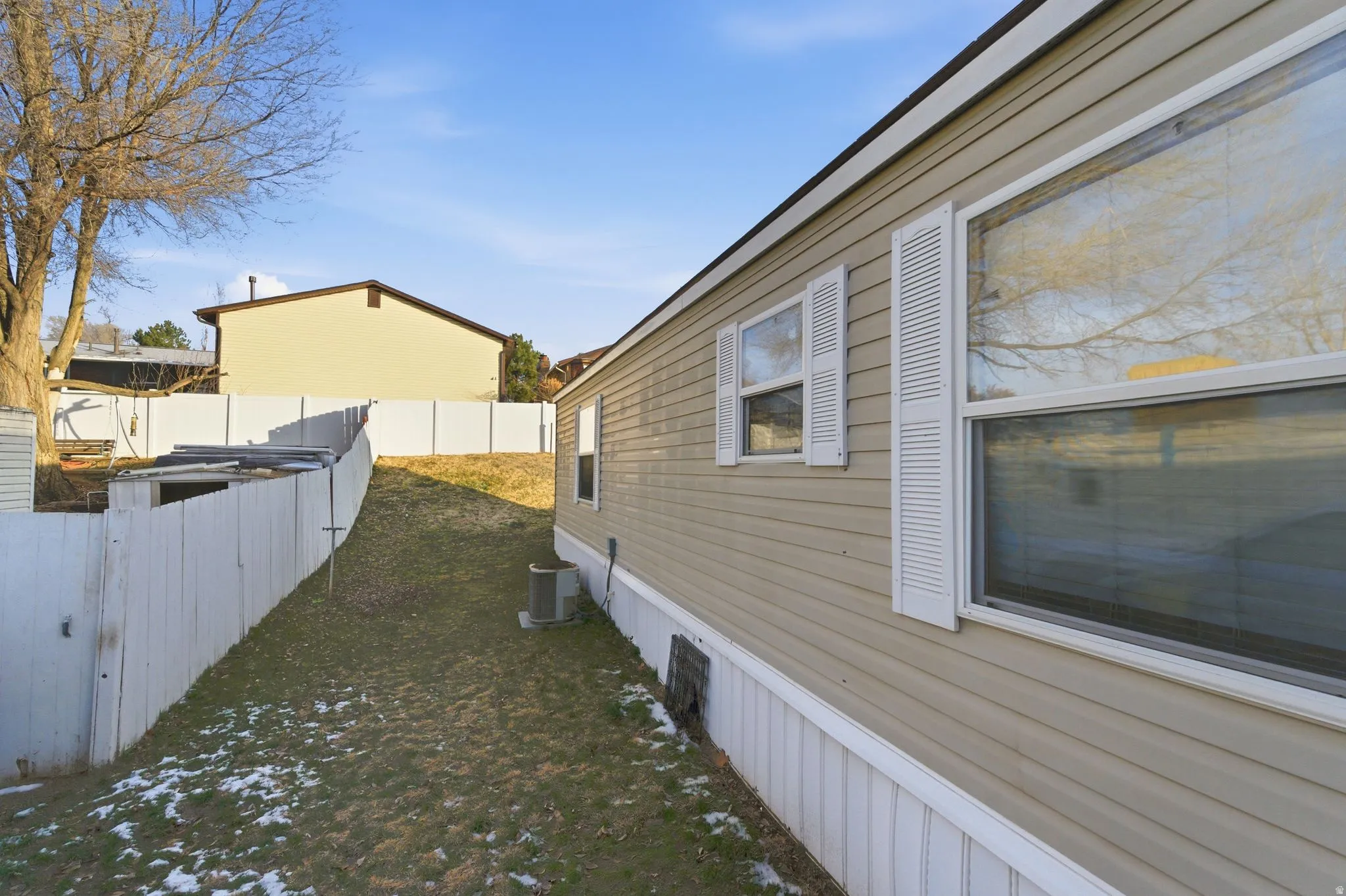 View of property exterior with a fenced backyard and a cooling unit