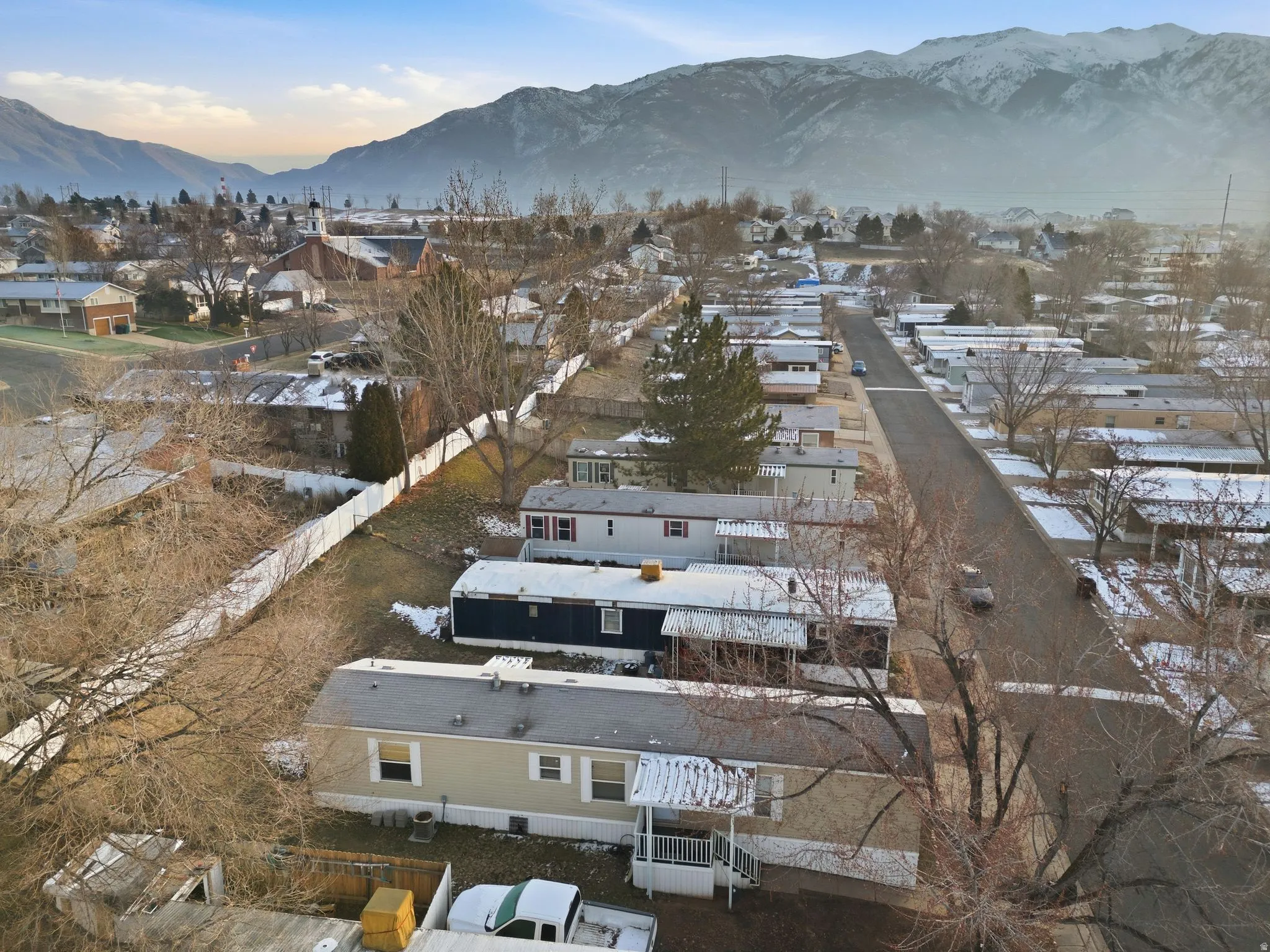 Snowy aerial view featuring a mountain view and a residential view