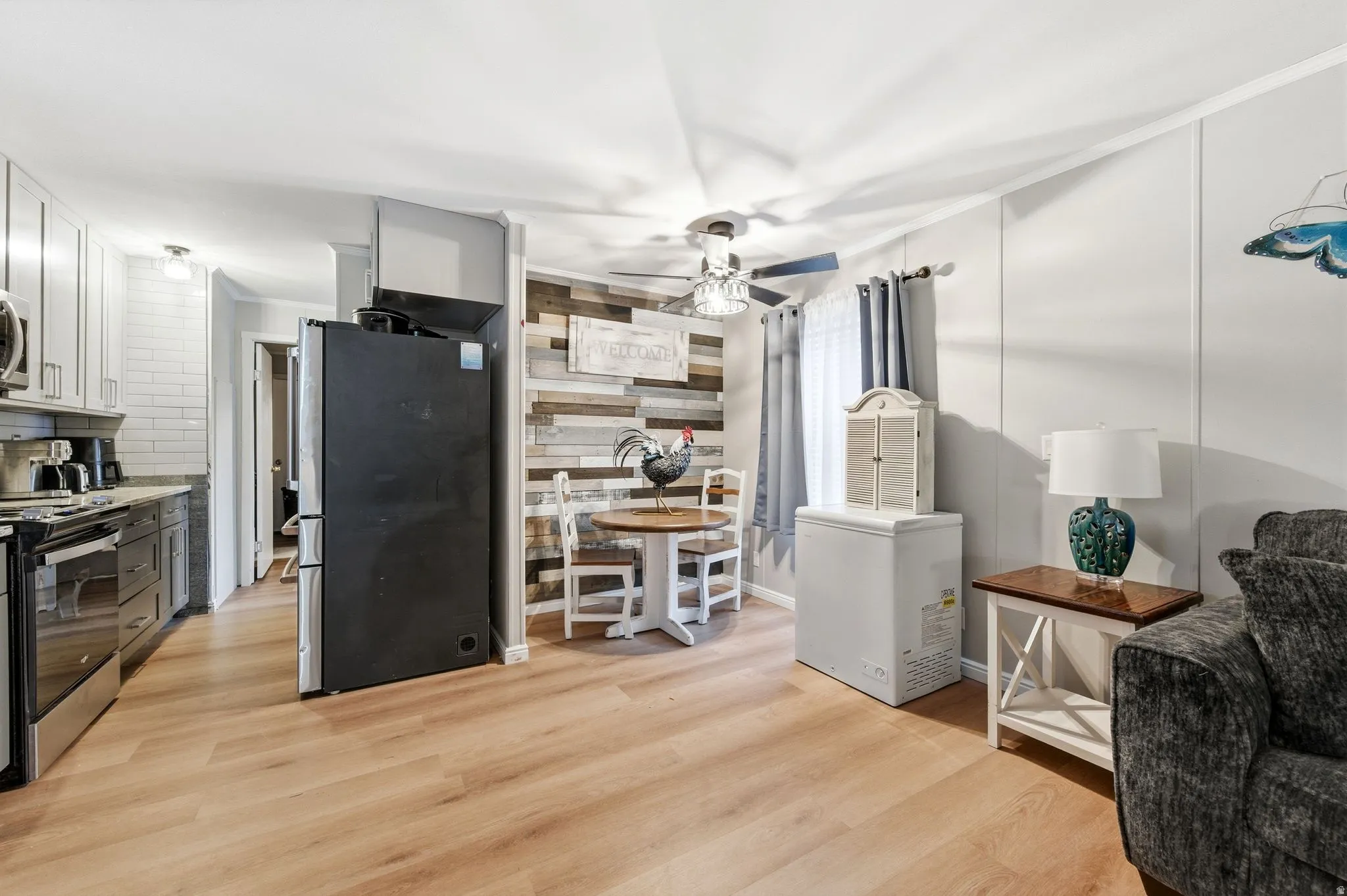 Kitchen featuring appliances with stainless steel finishes, light wood-type flooring, white cabinetry, gray cabinets, and ceiling fan