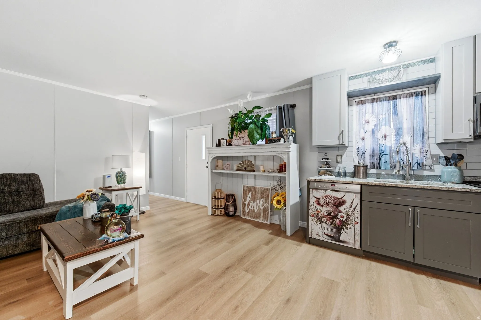 Living area featuring light wood-style floors and crown molding