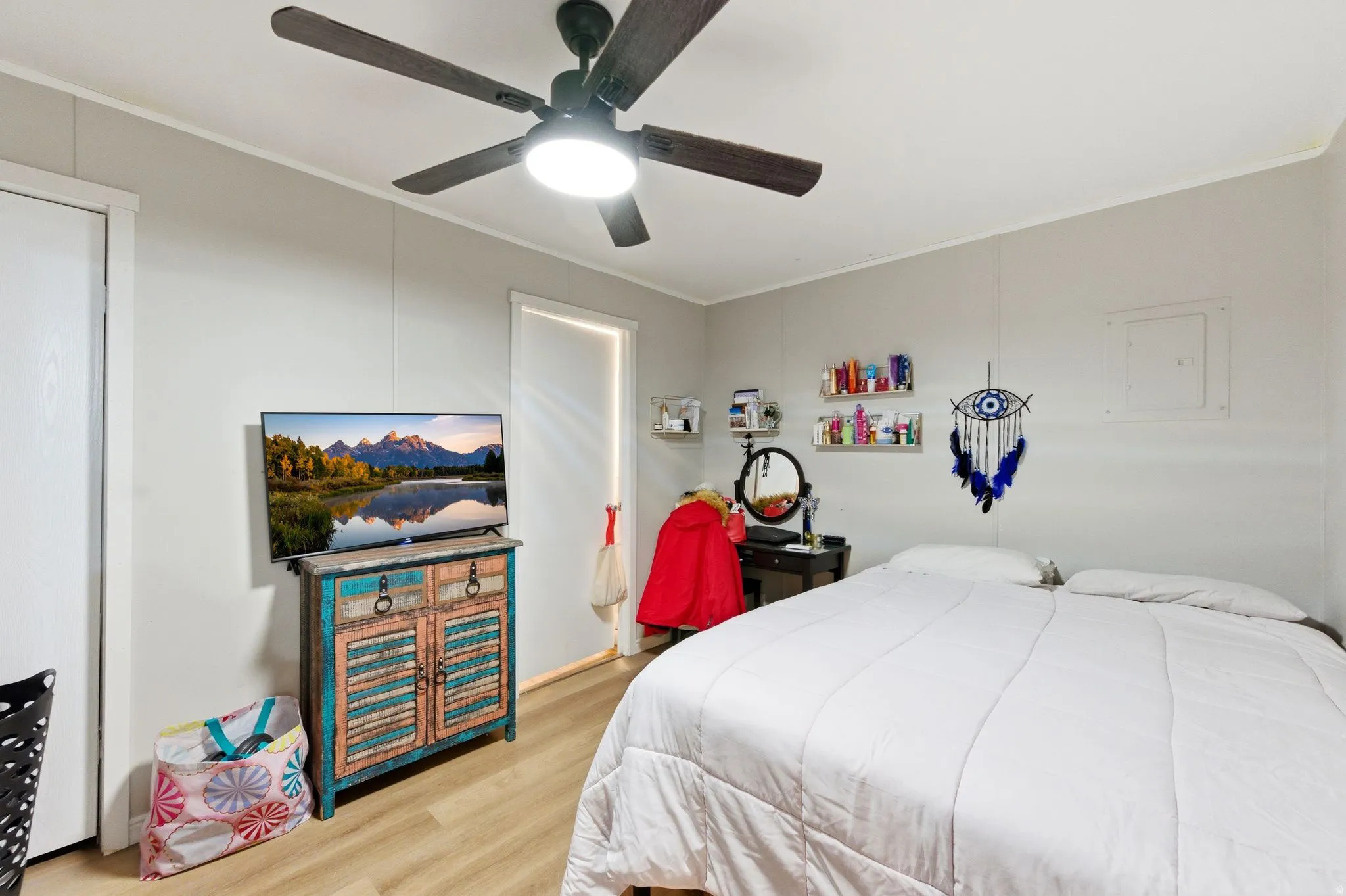 Bedroom with crown molding, light wood-style floors, and a ceiling fan