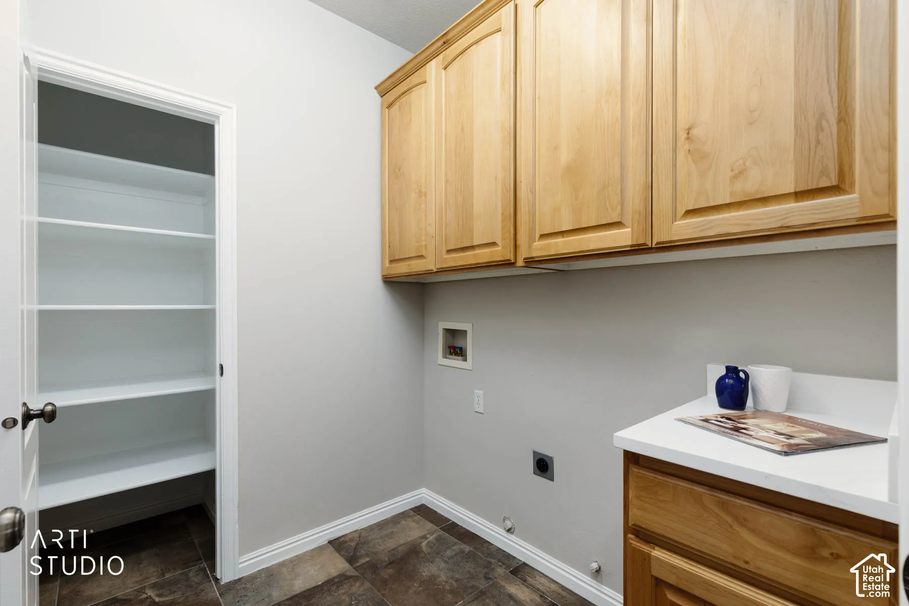 Washroom featuring washer hookup, gas dryer hookup, hookup for an electric dryer, stone finish flooring, and cabinet space