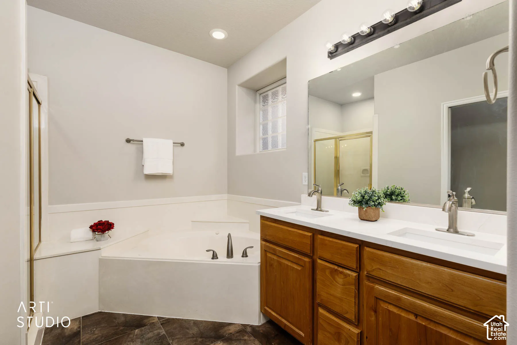 Full bath with a bath, double vanity, and a shower stall