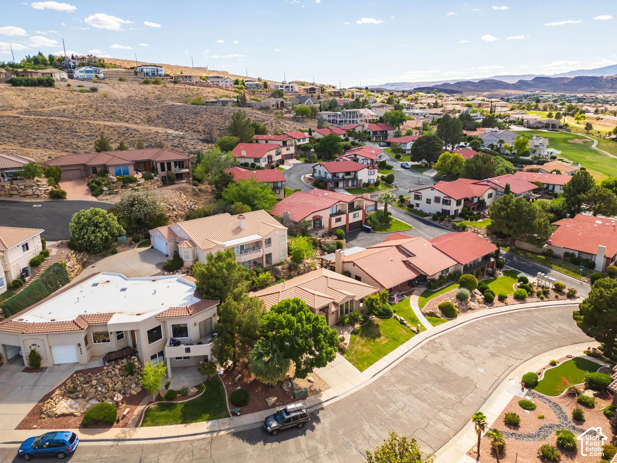 Aerial perspective of a residential neighborhood featuring varied architectural styles and red tile roofs