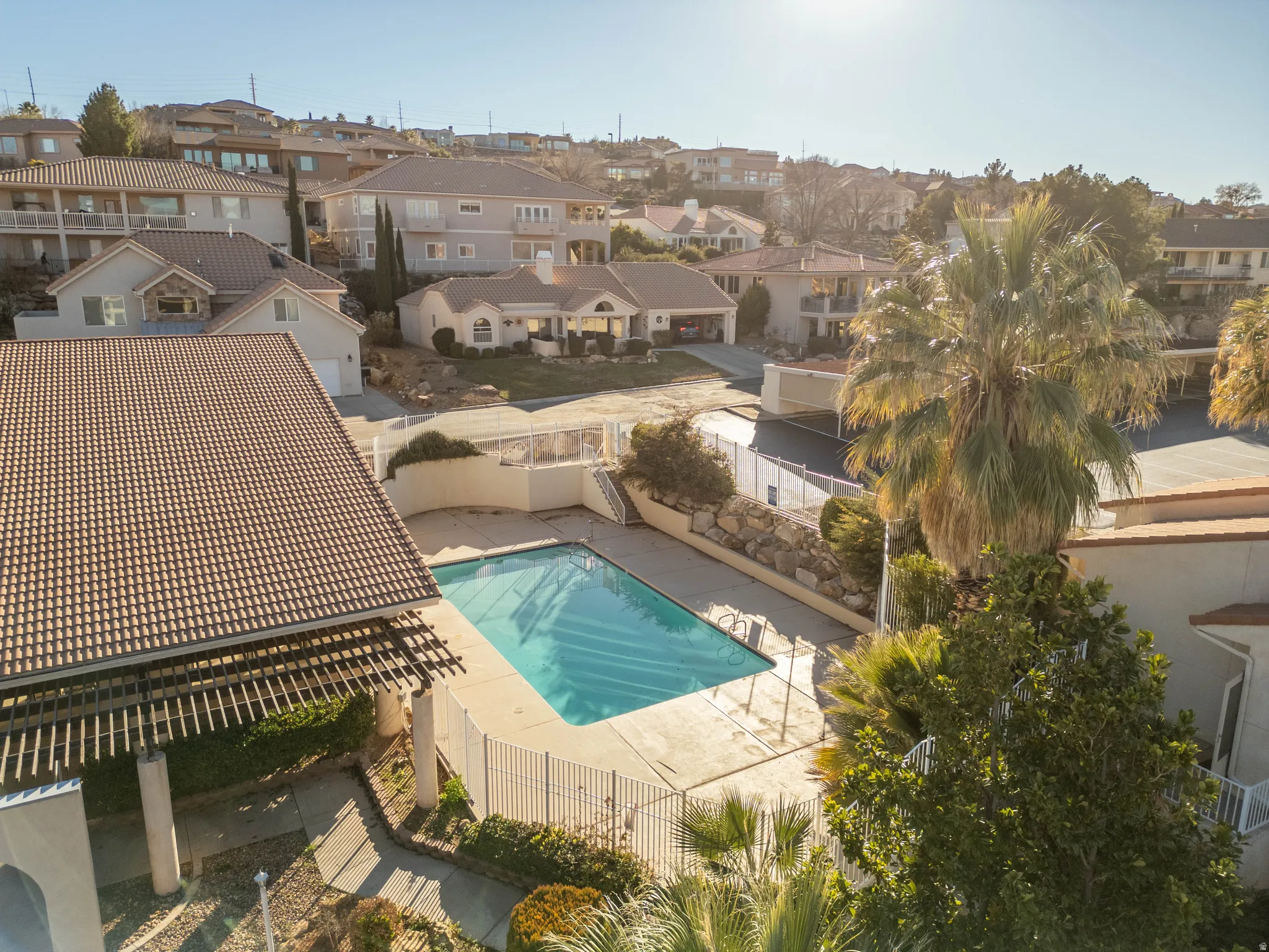 Community pool featuring a patio area, a fenced backyard, and a residential view
