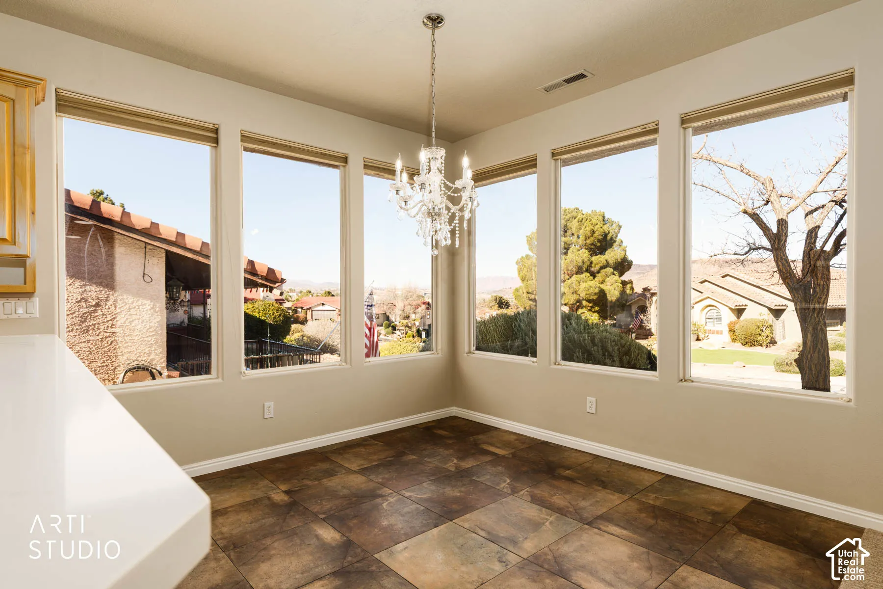 Unfurnished dining area with a chandelier and stone finish floors