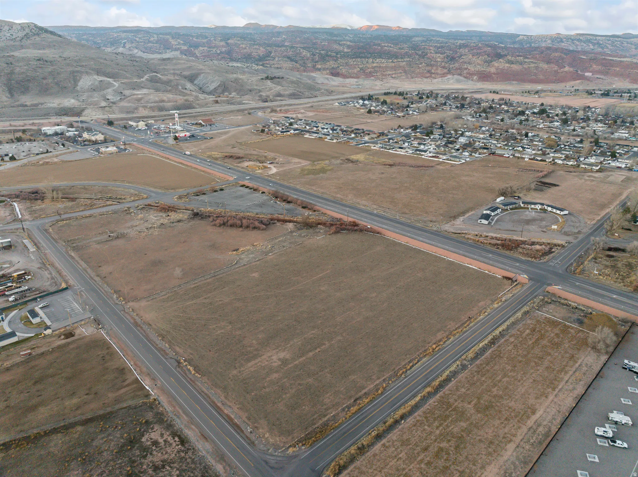 Aerial view of property and surrounding area featuring rural landscape and a mountainous background