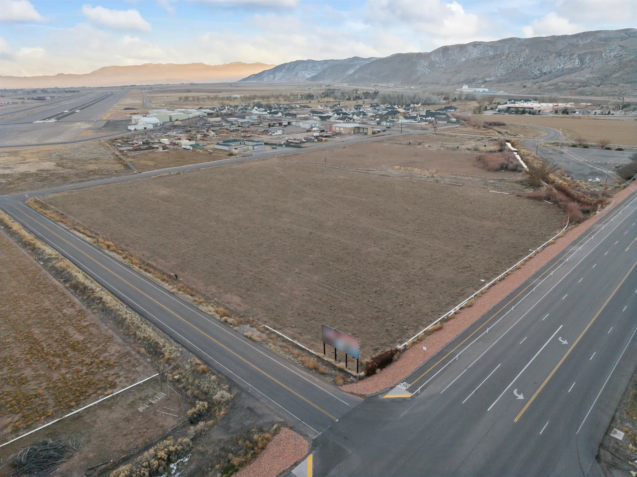 Aerial view of property and surrounding area with a mountain backdrop, nearby suburban area, and rural landscape