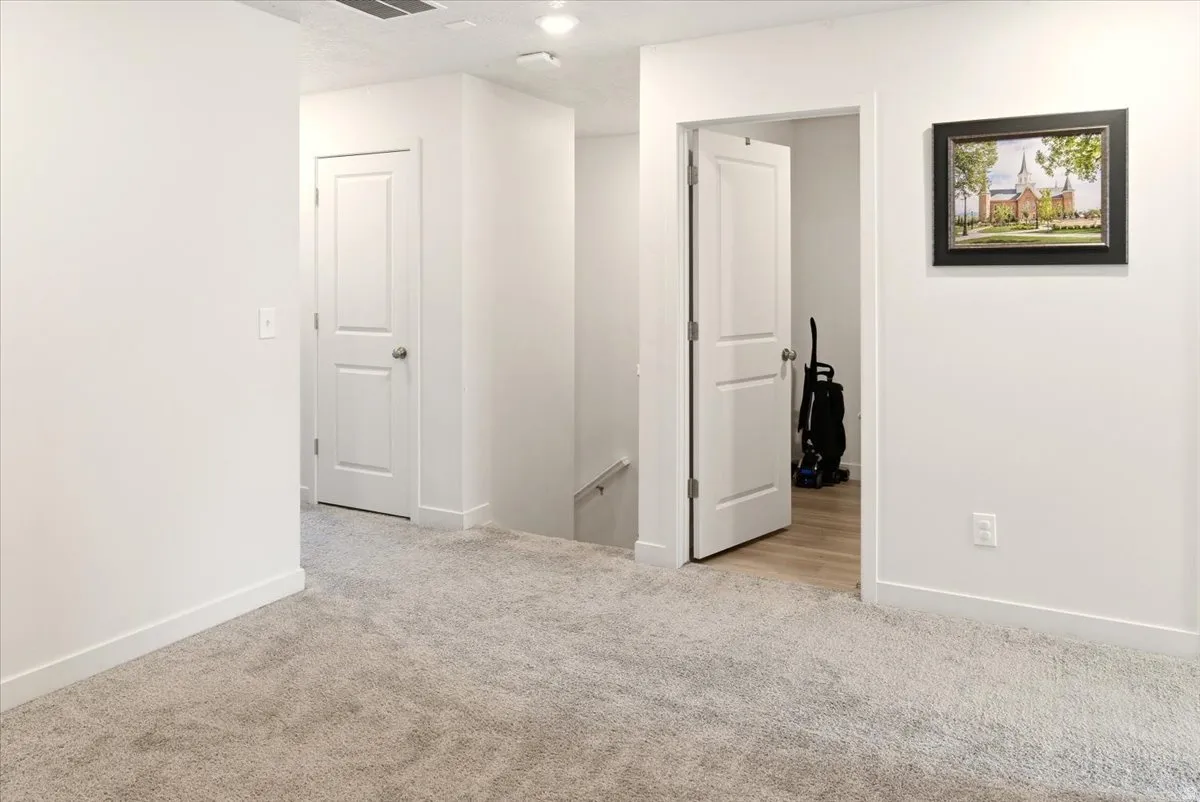 Spare room with light carpet and baseboards